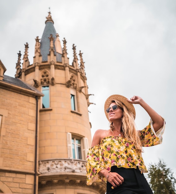 Donna bionda in un abito vintage giallo con un cappello