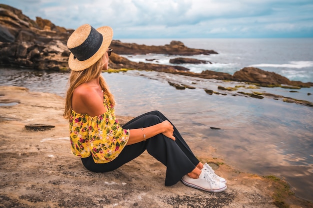 Donna bionda in una camicia floreale in spiaggia