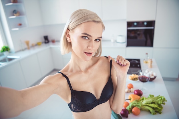 Donna bionda nella sua lingerie in posa in cucina