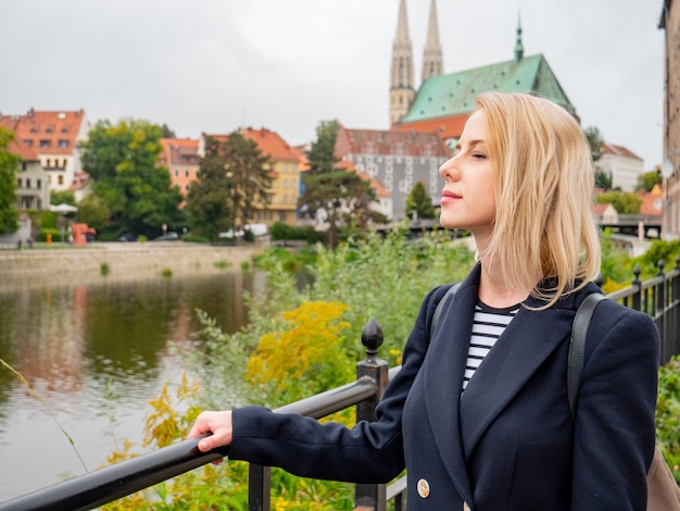 Donna bionda soggiorno su un ponte al confine tra Polonia e Germania a Gorlitz