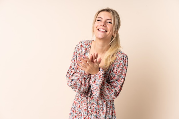 Donna bionda sopra la parete isolata che applaude dopo la presentazione in una conferenza