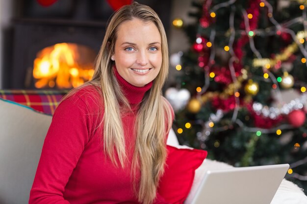 Donna bionda sorridente che utilizza computer portatile sullo strato