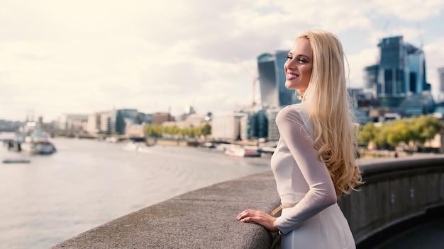 Donna bionda sorridente con l'orizzonte di Londra