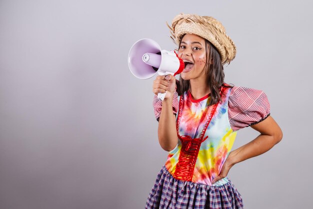 Donna brasiliana che indossa abiti di campagna Festa di Sao Joao Festa di Junina con pubblicità di promozione del megafono