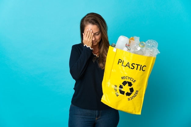 Donna brasiliana di mezza età che tiene una borsa piena di bottiglie di plastica