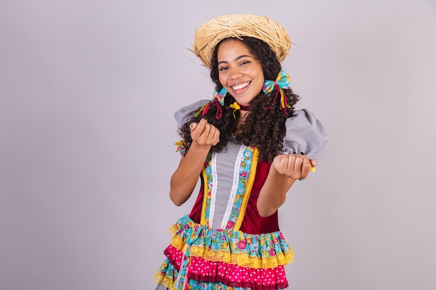 Donna brasiliana nera che indossa abiti da festa di giugno fraternizzazione nel nome di Sao Joao Arraial incredibile invitante con le mani