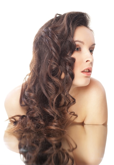 Donna bruna con lunghi capelli ondulati su bianco