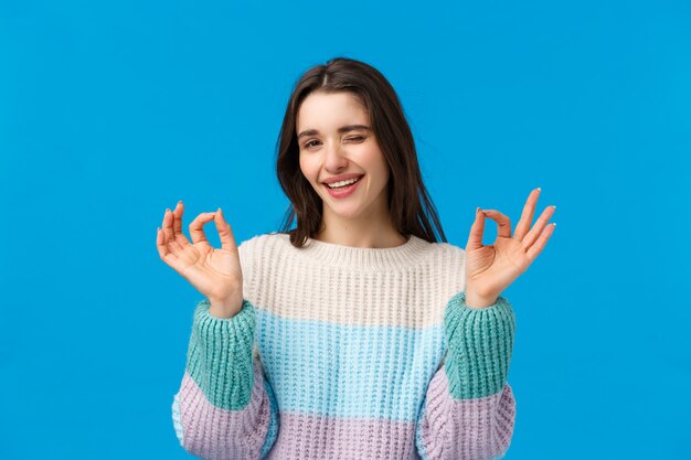 donna bruna con maglione invernale facendo segno ok