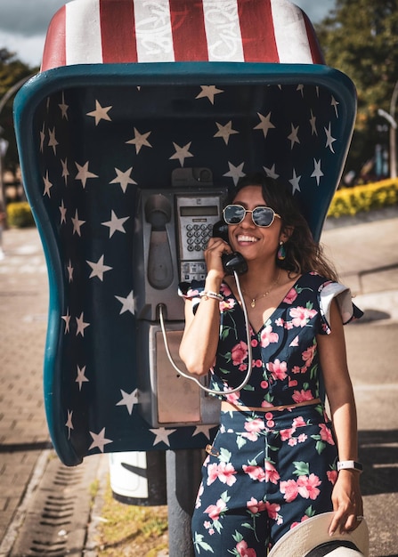 donna bruna utilizzando il telefono pubblico