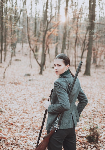 Donna cacciatrice caccia a caccia nella foresta autunnale ritratto di bellezza donna cacciatrice stagione di caccia