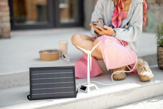 Donna carica il telefono da un pannello solare portatile