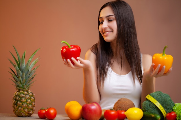 Donna carina con verdure fresche e frutta che conduce uno stile di vita sano