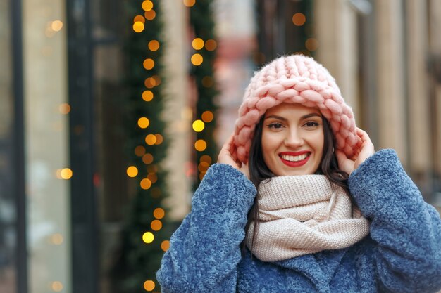 Donna castana allegra in cappotto che cammina in città in inverno. Spazio vuoto