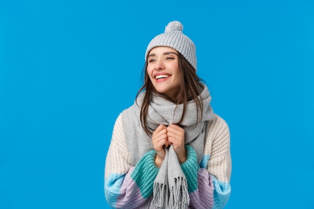 Donna castana di risata e sorridente allegra spensierata in cappello, sciarpa e maglione di inverno