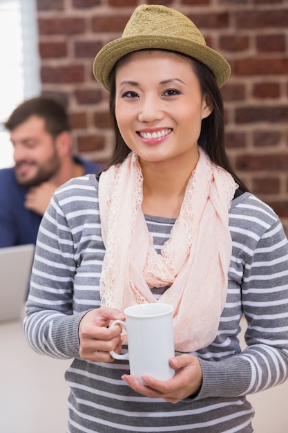 Donna casuale con la tazza di caffè in ufficio