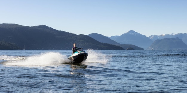 Donna caucasica avventurosa su moto d'acqua che guida nell'oceano