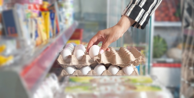 Donna caucasica che compra le uova al supermercato.