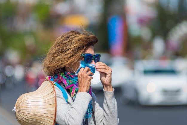 Donna caucasica che indossa maschera sanitaria all'aperto nel centro urbano Vietnam del Da Lat. Turista con protezione per mascherina medica contro il rischio di nuovo virus corona covid-19 in Asia