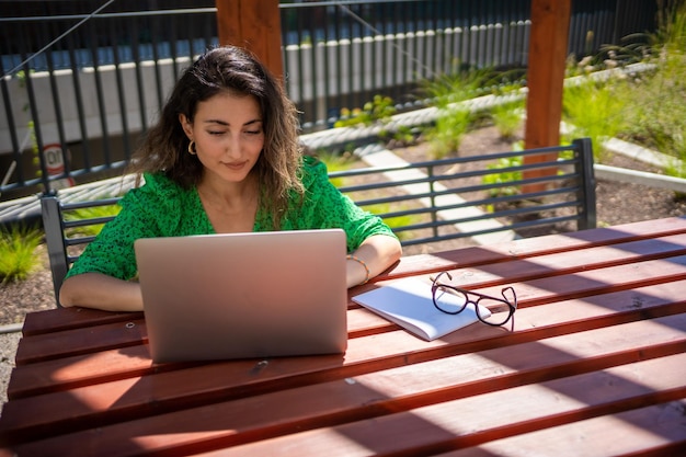 Donna caucasica che lavora con il computer portatile fuori dall'ufficio