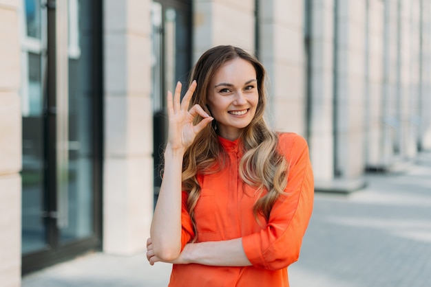 Donna caucasica che mostra gesto di mano bene in città.