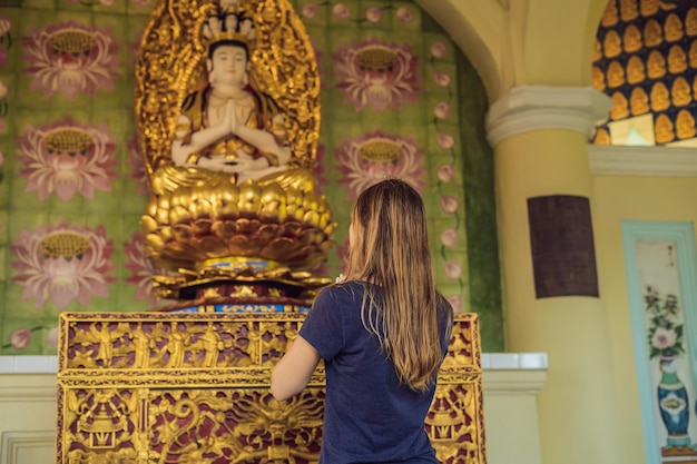 Donna caucasica che prega in un tempio buddista