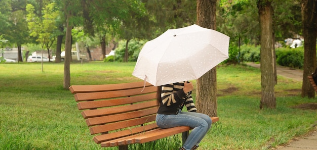 Donna caucasica che tiene ombrello nel parco