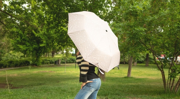 Donna caucasica che tiene ombrello nel parco