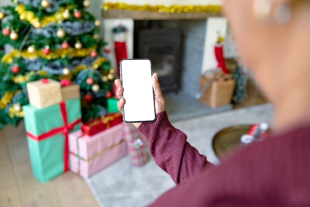 Donna caucasica che utilizza smartphone con spazio di copia nel periodo natalizio