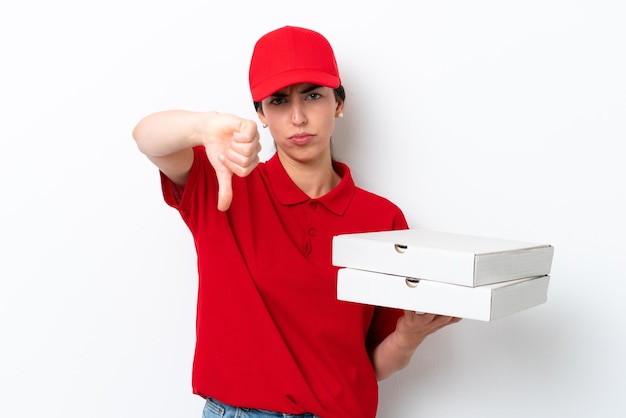 Donna caucasica consegna pizza con uniforme da lavoro che raccoglie scatole di pizza isolate su sfondo bianco che mostra il pollice verso il basso con espressione negativa