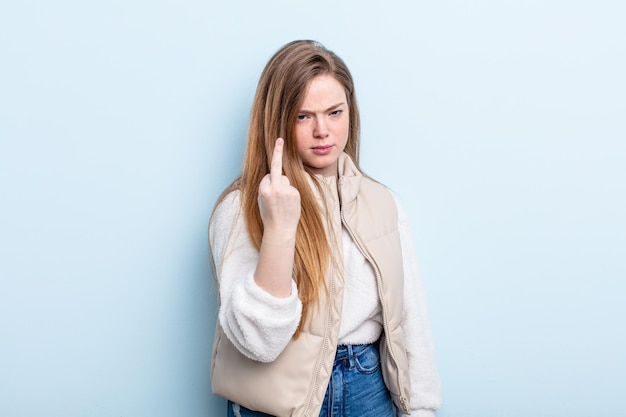 Donna caucasica dai capelli rossi che si sente arrabbiata, infastidita, ribelle e aggressiva, lanciando il dito medio, combattendo