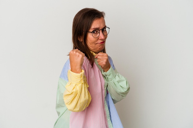 Donna caucasica di mezza età isolata su sfondo bianco che lancia un pugno, rabbia, lotta a causa di un argomento, boxe.