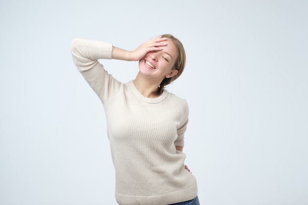 Donna caucasica di risata sopra il muro bianco