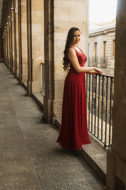 Donna caucasica in un ritratto di un abito di gala rosso prima di andare alla festa o alla vigilia di Capodanno