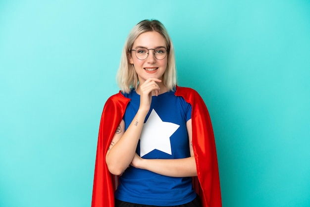 Donna caucasica Super Hero isolata su sfondo blu con occhiali e sorridente