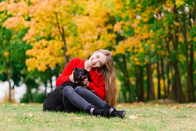 Donna che abbraccia cane nel parco estivo