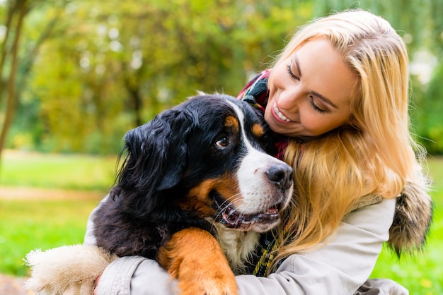 Donna che abbraccia il suo cane nel parco d&#39;autunno