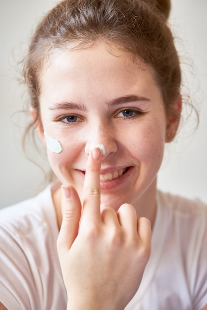 Donna che applica la crema per il viso