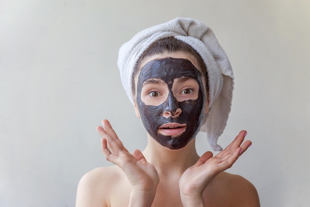 Donna che applica maschera nutriente nera sul viso