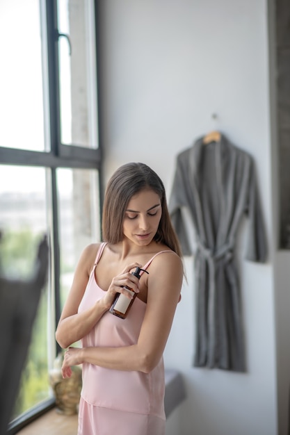 Donna che applica un olio per il corpo dopo aver fatto il bagno