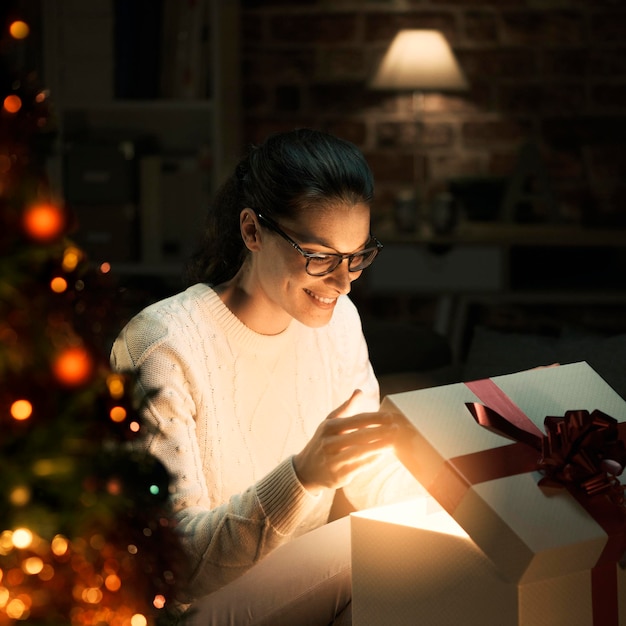 Donna che apre un magico regalo di Natale