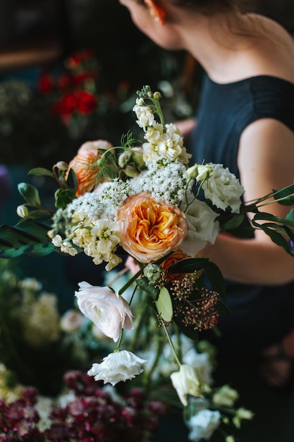Donna che arrangiò i fiori nel negozio