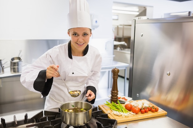 Donna che assaggia zuppa mentre cucina