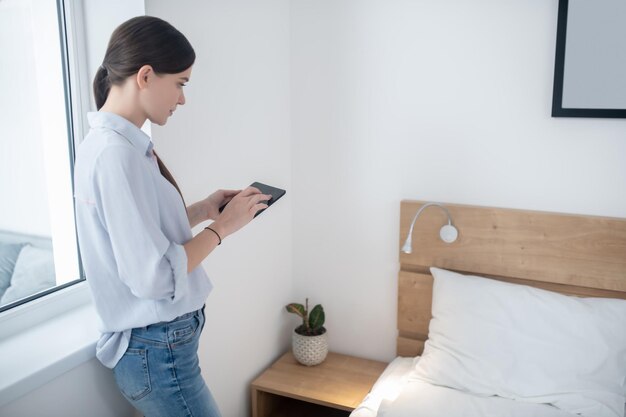 Donna che aziona un telecomando in camera da letto