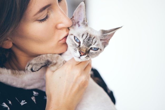 Donna che bacia il gatto a casa