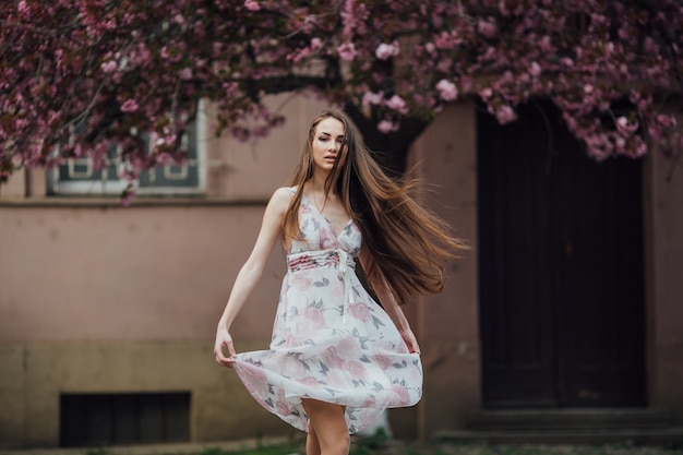 Donna che balla vicino all&#39;albero di fioritura