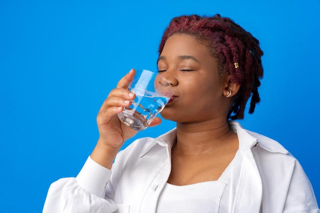 donna che beve acqua da un bicchiere