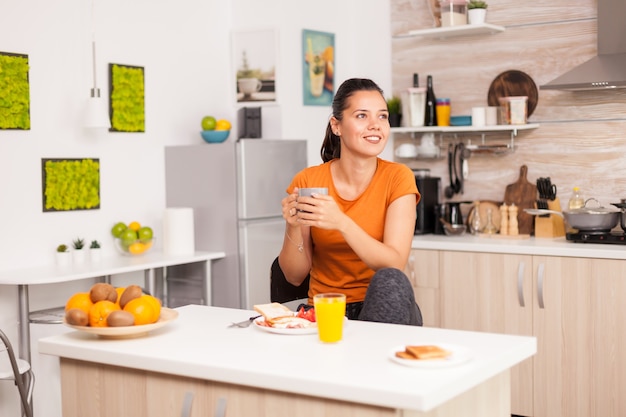 Donna che beve caffè caldo per svegliarsi la mattina