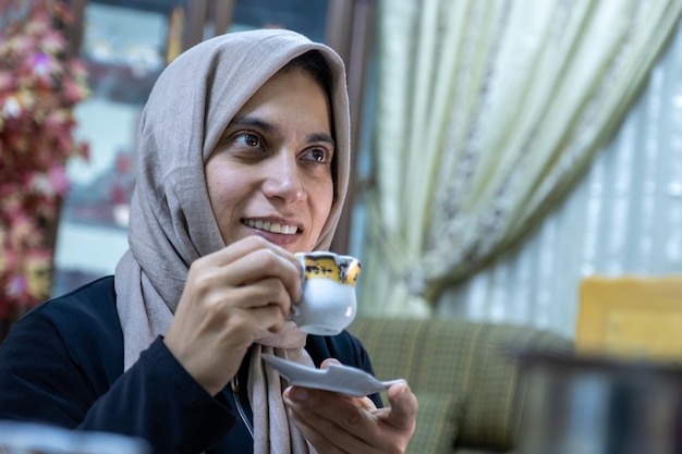 Donna che beve caffè con la faccia sorridente