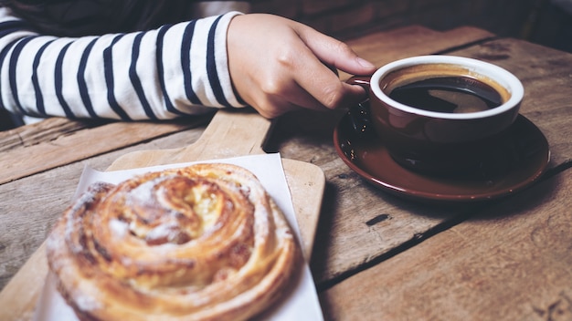 donna che beve caffè con un pezzo di dessert danese uva passa