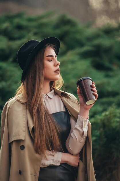 Donna che beve caffè da asporto mentre è fuori